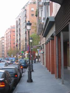 eine Stadtstraße mit parkenden Autos und Straßenbeleuchtung in der Unterkunft RASTRO in Madrid