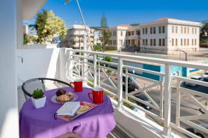a table with a plate of food on a balcony at Tres Jolie - Stylish Cityheart Apartment in Rethymno