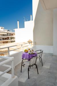 Una mesa con un mantel morado en un balcón. en Tres Jolie - Stylish Cityheart Apartment, en Rethymno