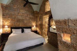 a bedroom with a bed in a stone wall at Alma in ‘Akko