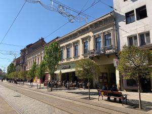 a street with people sitting on benches in a city at CENTER rooms in Miskolc