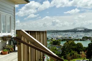 a balcony with a view of a harbor and a bridge at Million Dollar View in Auckland