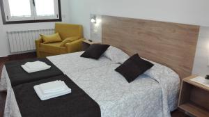 a hotel room with a bed and a chair at Albergue y Habitaciones Privadas Boente in Boente