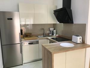 a kitchen with a stainless steel refrigerator and a sink at Apartments Jani in Hvar