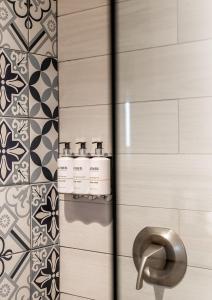 een badkamer met 3 shampooflessen aan de muur bij Boarding House Cape May in Cape May