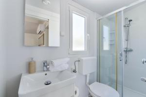 a white bathroom with a toilet and a sink at Mobile house Nord 1 Laguna in Turanj