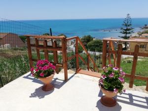two potted plants on a balcony with the ocean in the background at Villa Fiorella in Sciacca