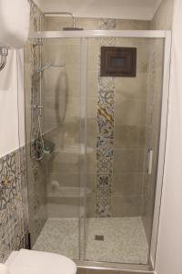 um chuveiro com uma porta de vidro na casa de banho em cocciu d'amuri em Caccamo