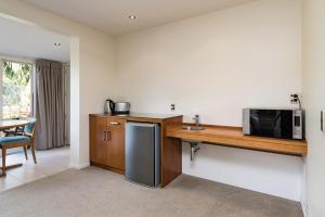 a kitchen with a counter with a microwave and a sink at Taipa Beach Resort in Taipa