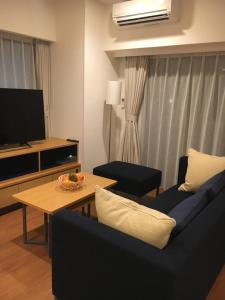 a living room with a couch and a table at Oakwood Apartments Nishi-Shinjuku in Tokyo
