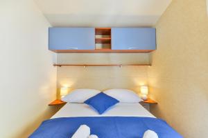 Mobile house 5 Laguna في توراني: غرفة نوم مع سرير مع وسادتين زرقاوين