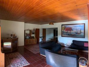 a living room with blue couches and a wooden ceiling at Casa na serra com cachoeira in Bom Jardim