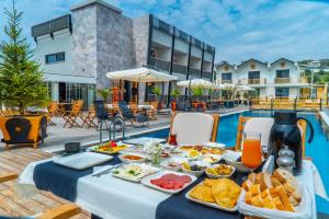 a table with food and drinks next to a pool at Kosa Otel Çeşme in Çeşme