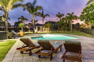 einen Pool mit 2 Liegestühlen und einem Pool in der Unterkunft Taipa Beach Resort in Taipa