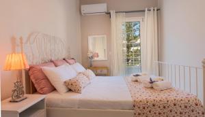 Un dormitorio con una cama con almohadas y una ventana. en Tres Jolie - Stylish Cityheart Apartment, en Rethymno