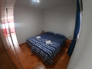 um quarto com uma cama com um cobertor azul e branco em Paradise apartament em Gran Tarajal