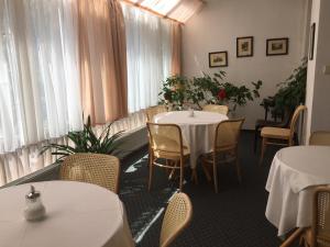 a restaurant with two tables and chairs and windows at Hotel-Pension KAMÝK in Prague