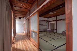 un pasillo de una habitación con una habitación con suelo en Kamp Houkan-cho Backpacker's Inn & Lounge en Okayama