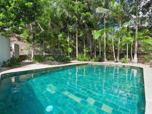 a swimming pool with blue water in front of trees at surfside6 @ james cook - Clarkes Beach in Byron Bay