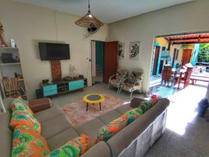 a living room with a couch and a tv at Farofa Loca Hostel in Morro de São Paulo