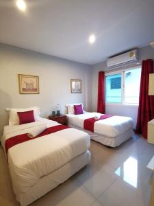 1 dormitorio con 2 camas y ventana en ibeyond Apartment Romklao Suvarnabhumi en Lat Krabang