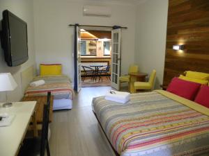 Cette chambre comprend deux lits, une table et des chaises. dans l'établissement Ettalong Beach Tourist Resort, à Ettalong Beach