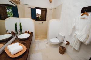 a white bathroom with a toilet and a sink at Hotel Boutique Bahia Bonita in Trancoso