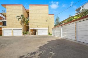 a house with two garages and two white garage doors at Golden Shores Unit 3 21 Landsborough Parade in Caloundra