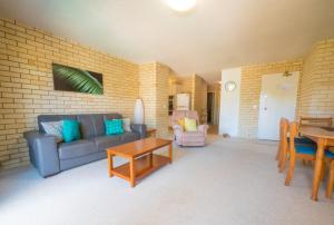 a living room with a couch and a table at Golden Shores Unit 3 21 Landsborough Parade in Caloundra