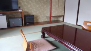 ein Wohnzimmer mit einem Tisch und 2 Stühlen in der Unterkunft Oyado Matsubaya in Minakami