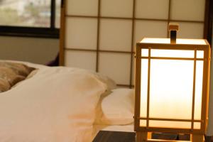 a lamp sitting on a table next to a bed at Oyado Matsubaya in Minakami