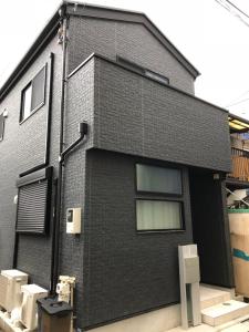 una casa de ladrillo negro con dos retretes a un lado. en CuteFamilyHouse! 8min Shinjuku 5minJR 3minSubway Cozy,Quiet KidsFree Under6yrs en Tokio