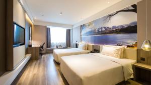 HoumaにあるAtour Hotel (Houma Xintian Square)のベッド2台とテレビが備わるホテルルームです。