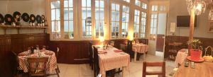 a restaurant with two tables and chairs and windows at Hotel Isla Bella Talca in Talca