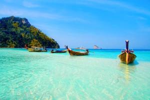 three boats sitting in the water on a beach at At Seacondo-1 Bedroom-A25 in Klong Muang Beach