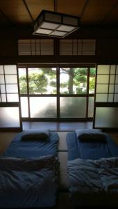 pokój z 2 łóżkami w pokoju z oknami w obiekcie TSUMUYA w mieście Naoshima