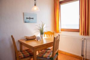 a dining room table and chairs with a table and a window at Strandhaus Nr. 9 OG re. in Dahme