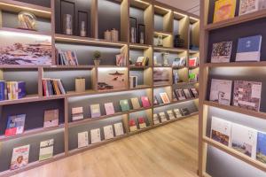 een bibliotheek met veel boeken op de planken bij Atour Hotel (Kong Family Mansion) in Qufu