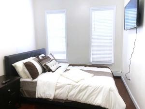 een slaapkamer met een bed met witte lakens en kussens bij Rochester's Place in Brooklyn