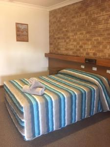 a bed with two pillows on top of it at Nanango Fitzroy Motel in Nanango