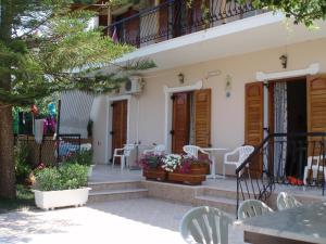 a patio of a house with chairs and tables at Villa Xenos in Kalamaki