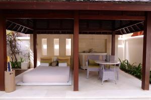 a patio with a bed and a table and chairs at The Royal Santrian in Nusa Dua