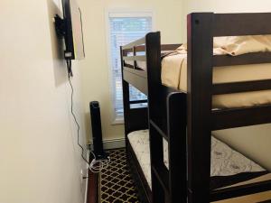 a room with two bunk beds and a television at DaBreo's Place in Brooklyn