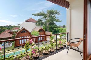 een balkon met uitzicht op een huis bij Villa Allamanda by Kubu GWK in Jimbaran