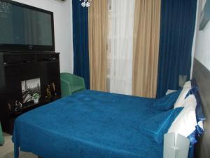 een slaapkamer met een blauw bed en een flatscreen-tv bij Milla's house rome in Rome