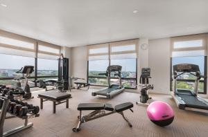 un gimnasio con un montón de equipos de ejercicio y ventanas en Seda Capitol Central Hotel en Bacólod