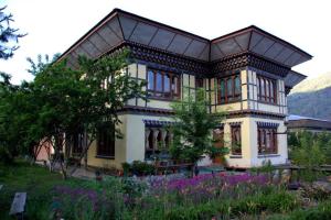 a large house with flowers in front of it at Nirvana Lodge in Paro