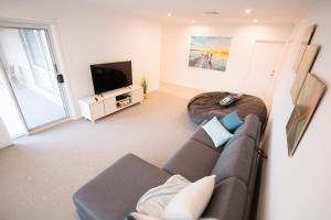 ein Wohnzimmer mit einem Sofa und einem TV in der Unterkunft ‘Serenity’ and sweeping Murray River views in Tailem Bend