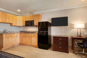 a kitchen with a black refrigerator and wooden cabinets at Days Inn by Wyndham Eureka CA in Eureka