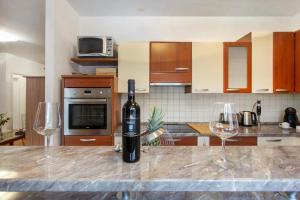 a bottle of wine sitting on a counter with two wine glasses at Relax Centar Apartment in Podgorica